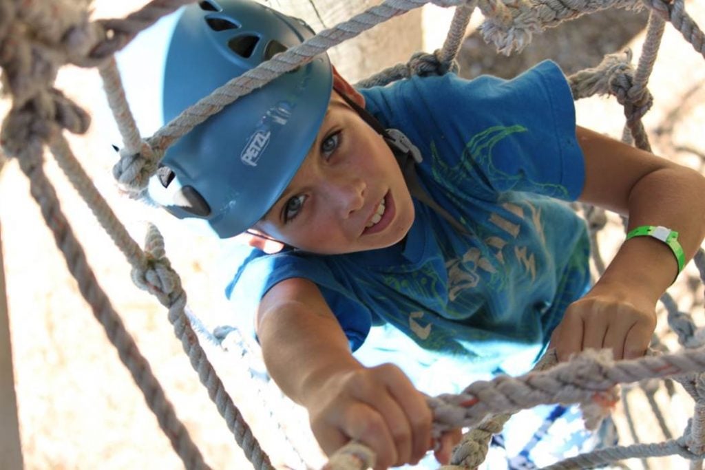 camper climbing high ropes